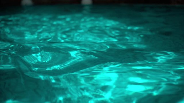 Ripple turquoise water in swimming pool with sun reflection