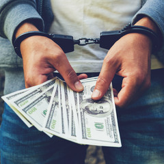 arrested rowdy in handcuffs counting dollar banknote. Arrested for attempting to bribe. Concept of...