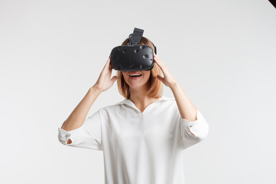 Woman with virtual reality goggles. Studio shot, white background