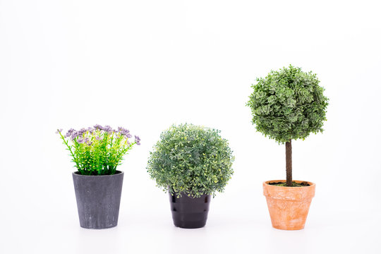 Set small artificial tree in a pot isolated in white background.