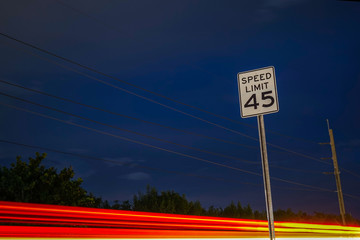 Light Trails Past a Speed Limit Sign