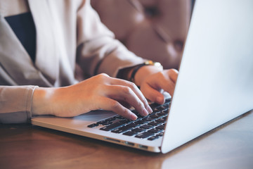 Closeup image of an Asian business woman working and typing on laptop keyboard in office