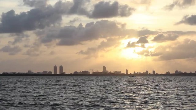 Fisherman Working Hard on Fishing Boat in the Early Morning with Skyline of Miami and Sunrise