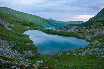 Panoramic photo of a mountain lake in a mountainous rocky valley. Serene lake Berbeneskul, Carpathians, Ukraine.