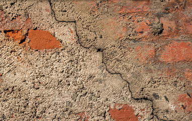 Background of the cement wall grey plain textured with a crack diagonally with elements of red brick.
