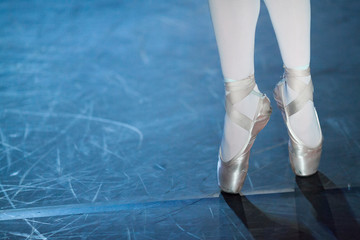 choreography, passion, equipment concept. pointe shoes bound in satin in shades of tender light pink and elastic ribbons are tied around ankles of slender ballerina