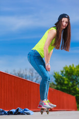 Teen girl skater riding skateboard on street.