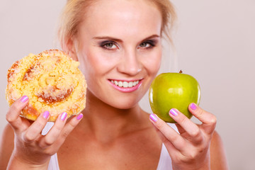 Woman holds cake and fruit in hand choosing
