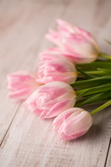 Obraz na płótnie Canvas Pastel Pink and White Tulips on Wood Floor