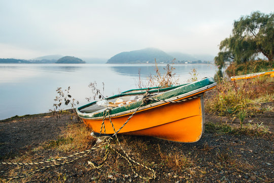 Orange Wooden Boat on Lake Shore