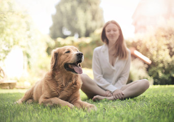 Girl sitting in the grass with her dog
