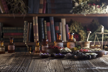 Natural medicine. Shallow depth of focus. Wooden table. Herbs, berries and flowers in bowls. Beautiful bokeh.