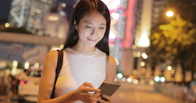 Woman using cellphone at outdoor in the evening