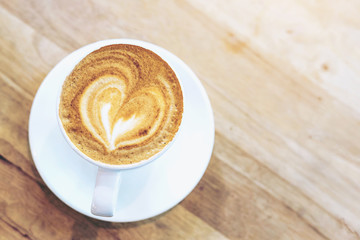 Hot art coffee cappuccino in a cup on wooden table background  with copy space