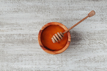 Honey in wooden bowl with honey dipper