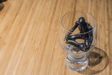 Figurine en plastique noir méditant dans un verre. Être dans sa bulle.