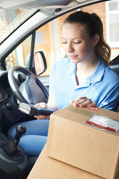 Female Courier In Van Delivering Package To House