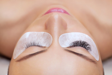 Eyelash removal procedure close up. Beautiful Woman with long lashes in a beauty salon. Eyelash...