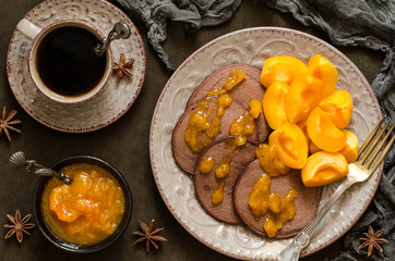 Chocolate pancakes with apricot jam and coffee