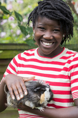 Portrait Of Girl In Garden Looking After Pet Guinea Pig