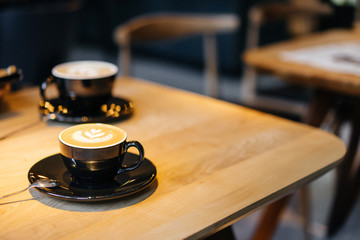 Fototapeta na wymiar Coffee drink in a black mug on a wooden table.