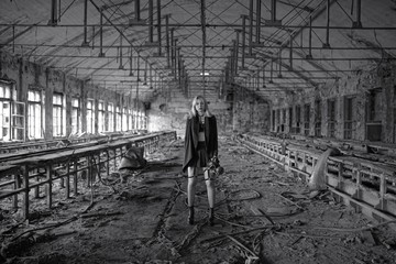 Beautiful, young girl post apocalypse girl stand in abandoned factory