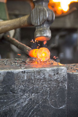 Métal en train d'être forgé sur l'enclume. Métal incandescent, chauffé au charbon.