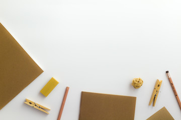 Top view of white table with pencil, notebook, brown paper and paper bag