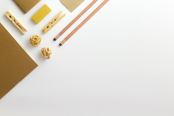 Top view of white table with pencil, notebook, brown paper and paper bag