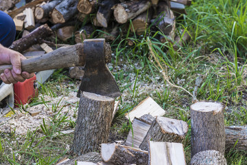 Stocking up of firewood/men chopp wood with ax
