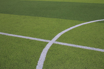 Photo of a green synthetic grass sports field with white line shot from above