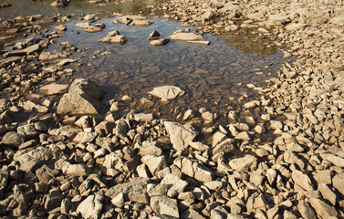 dried lake bed on the mountain with rocks