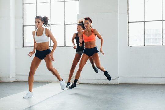 Young multiethnic women doing exercises at indoors bootcamp.