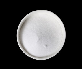 Salt pile in bowl isolated on black background