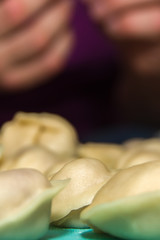 Dumplings hand-made on the background of hands