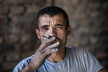Portrait of a poor man with a cigarette