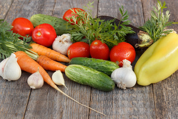 Different fresh vegetables on wooden background Tomato cucumber eggplant pepper carrot greens