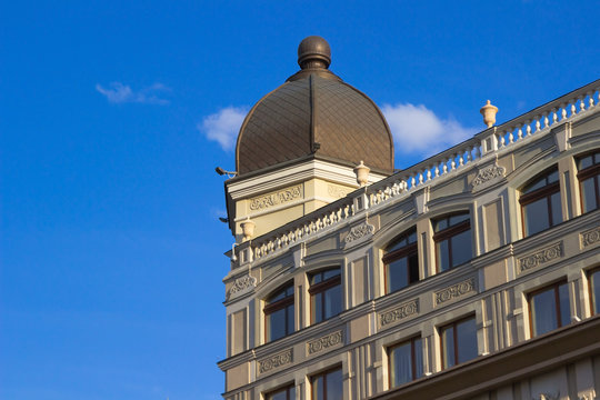 Fragment of building with dome on blue sky background