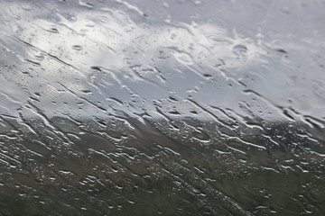 Sloping streams of water on glass with blurring background