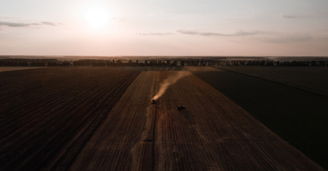 Obraz premium Harvester machine working in field . Combine harvester agriculture machine harvesting golden ripe wheat field. Agriculture. Aerial view. From above.