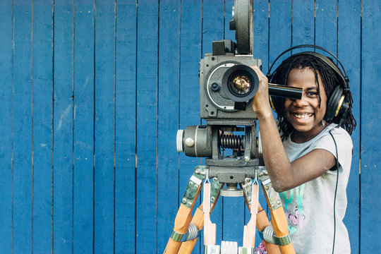Smiling black girl with motion film camera