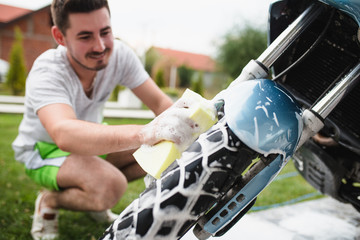 A man cleaning motorcycle - motorcycle detailing (or valeting) concept. Selective focus. 