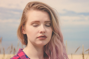 Fashion portrait of young hipster women enjoying sun. Summer concept, sandy beach, bright sky and sea. Tourism, travel, holidays.