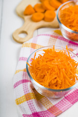 Grate  carrots in a bowl