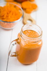 Carrot juice on a wooden table