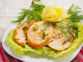 Roll chicken with greens and vegetables on the plate