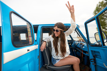 happy hippie woman showing peace in minivan car