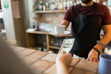 man or bartender serving customer at coffee shop