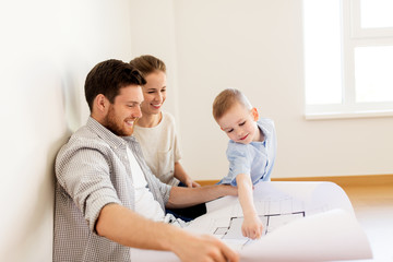 happy family with blueprint moving to new home