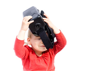 girl child is playing with virtual reality goggles. Studio shot, isolated on white background